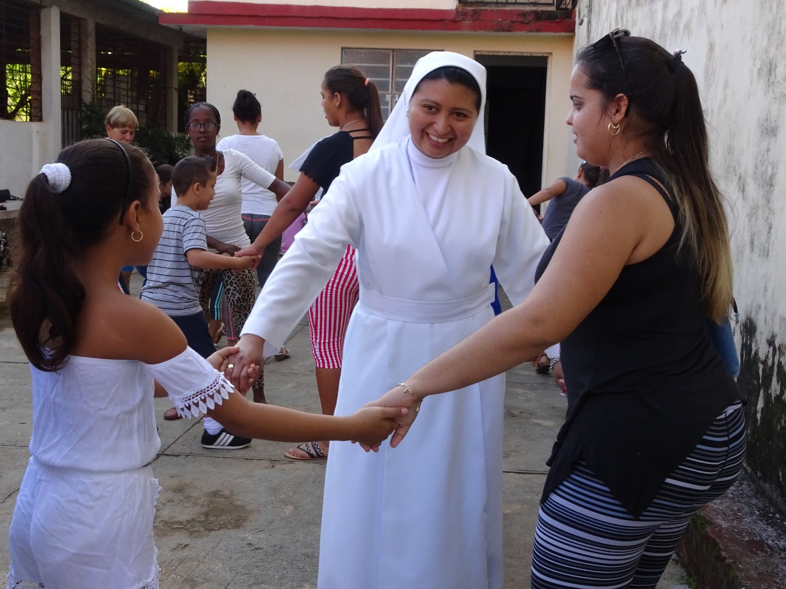 Una hermana juega con una niña y una mamá en el patio